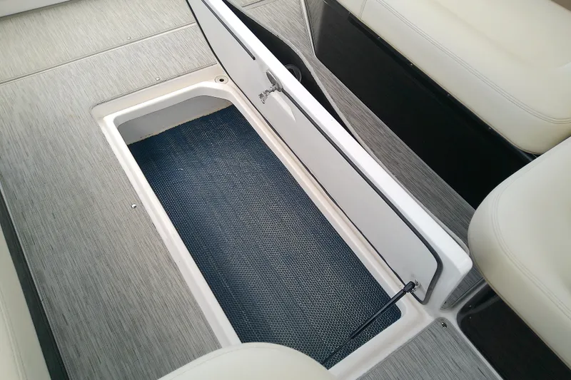 Slide: The Image of 2019 Regal 29 OBX boat storage compartment with open hatch and carpeted interior. - 46