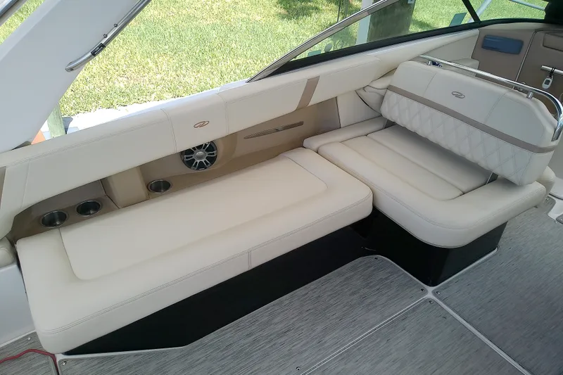 Slide: The Image of Luxurious seating on 2019 Regal 29 OBX boat, featuring beige upholstery and cup holders. - 20