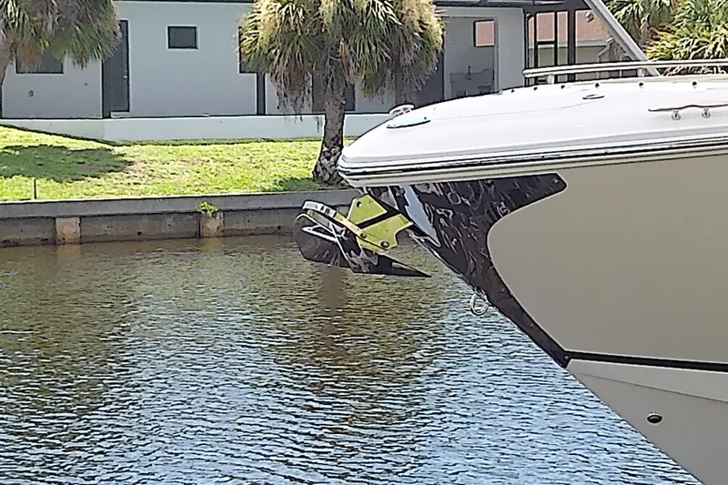 Slide: The Image of 2019 Regal 29 OBX boat anchored near a modern house by the water. - 6