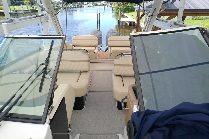 Slide: The Image of Interior view of a 2019 Regal 29 OBX boat with beige seating and open windshield. - 41
