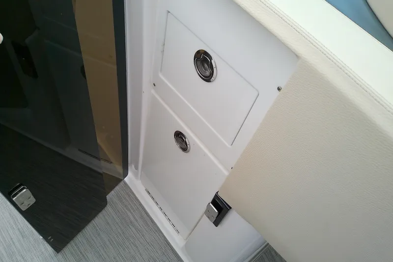 Slide: The Image of Storage compartments on a 2019 Regal 29 OBX boat, featuring sleek design and chrome handles. - 43