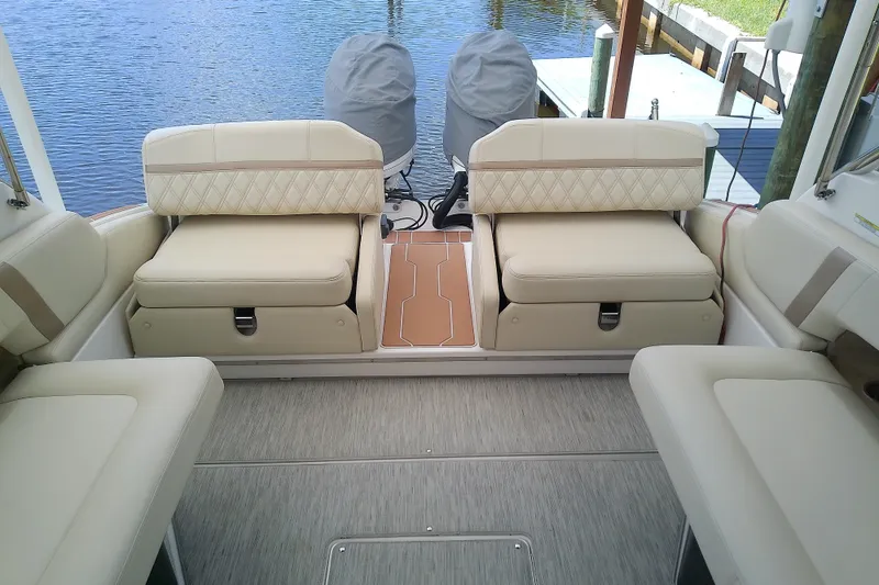 Slide: The Image of 2019 Regal 29 OBX boat interior with beige seating and covered outboard motors. - 13