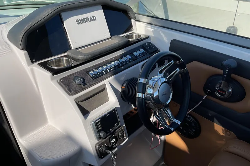 Slide: The Image of 2019 Rinker 290 Express Cruiser helm with Simrad display and modern controls. - 12