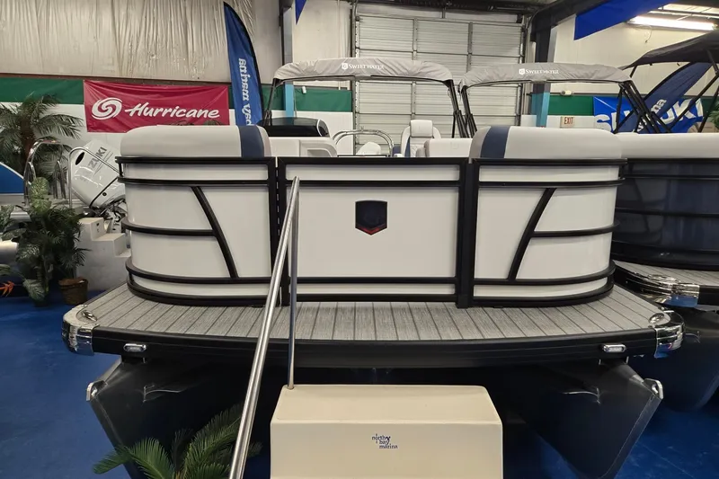 Slide: The Image of 2027 Godfrey Sweetwater 2286 SBC pontoon boat displayed indoors with sleek design. - 2