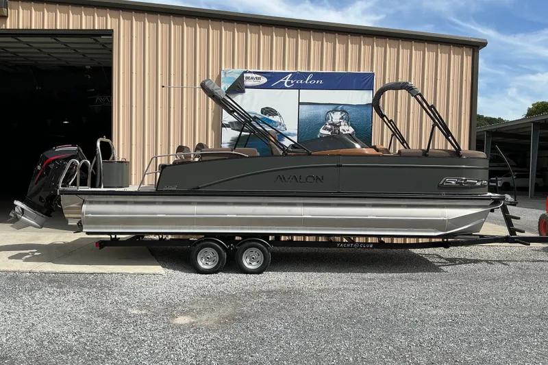The Image of 2027 Avalon Catalina Quad Lounge pontoon boat on trailer outside a warehouse. - 2