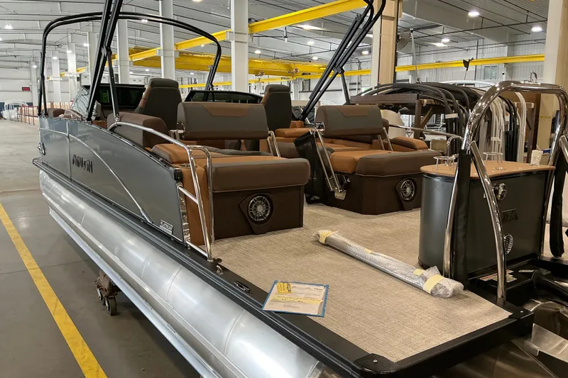 Slide: The Image of 2027 Avalon Catalina Platinum Quad Lounge Windshield boat in a showroom, showcasing luxury seating. - 3