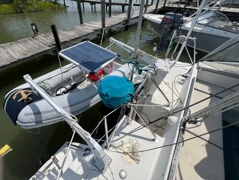Slide: The Image of A 1993 Gemini Catamaran 3400 docked. An attached dinghy features a solar panel. - 11
