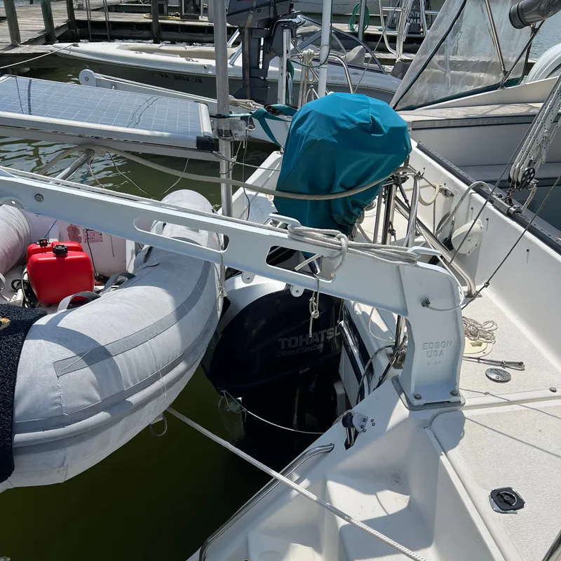 Slide: The Image of A 1993 Gemini Catamaran 3400 docked. Visible are a dinghy and an outboard motor. - 12
