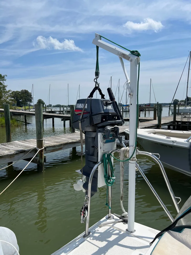 Slide: The Image of An outboard motor is mounted on a hoist system on a catamaran. Boats and a dock are visible in the background. - 15