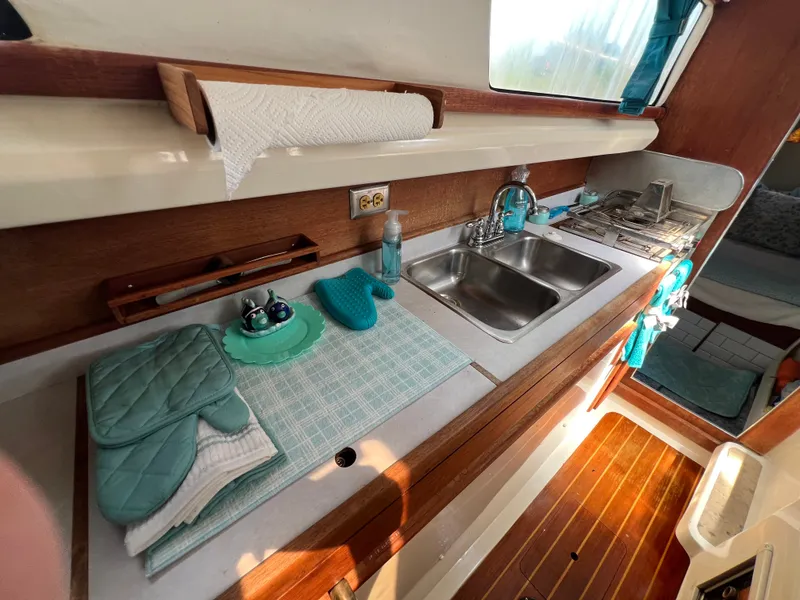 Slide: The Image of The galley of a 1993 Gemini Catamaran 3400 with sink, stove, and wood paneling. - 7