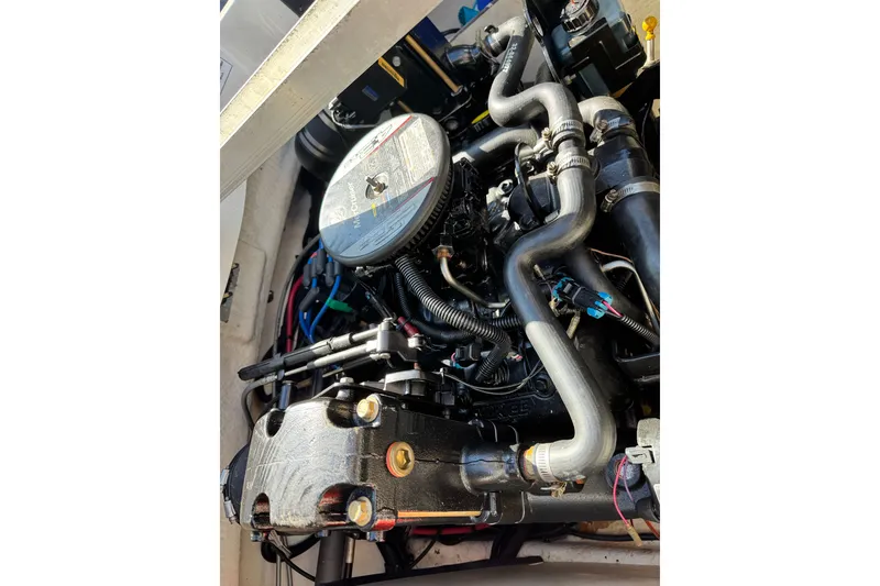 Slide: The Image of Engine of a 2010 Sea Ray 185 Sport boat, showcasing intricate components and hoses. - 14