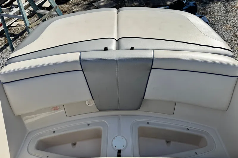 Slide: The Image of 2010 Sea Ray 185 Sport boat seating area with white and gray upholstery. - 11