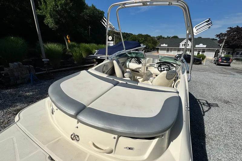 Slide: The Image of 2010 Sea Ray 185 Sport boat with seating, parked outdoors on gravel. - 2