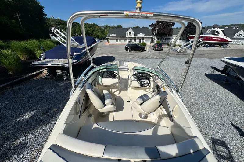 Slide: The Image of 2010 Sea Ray 185 Sport boat interior with steering wheel, seats, and open cockpit view. - 4
