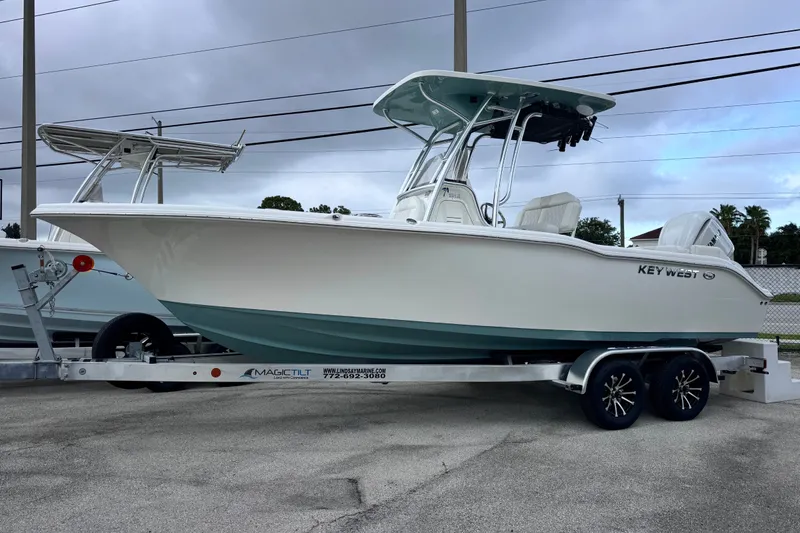 The Image of 2027 Key West 239 FS boat on trailer, displayed outdoors under cloudy sky. - 6