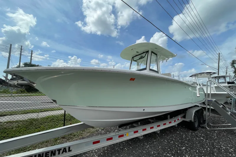The Image of 2021 Sea Hunt Gamefish 25 boat on trailer under a cloudy sky. - 0