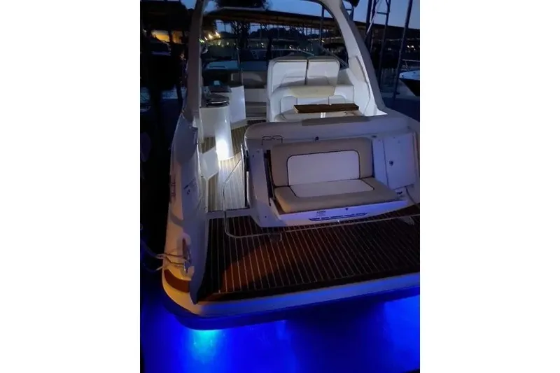 Slide: The Image of 2010 Sea Ray Sundancer 330 yacht with illuminated deck and seating area at night. - 4