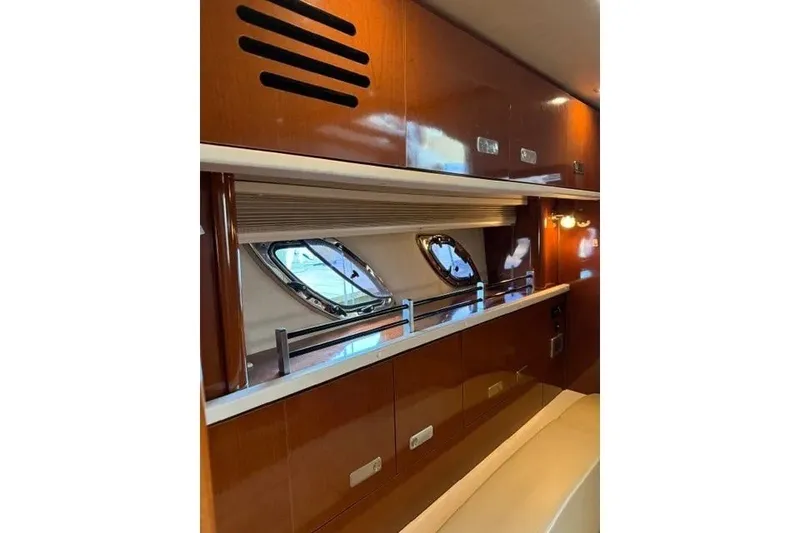 Slide: The Image of Interior of 2010 Sea Ray Sundancer 330 yacht with wooden cabinets and porthole windows. - 18