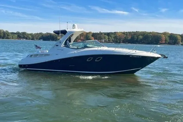 The Image of 2010 Sea Ray Sundancer 330 cruising on a serene lake under a clear blue sky. - 0