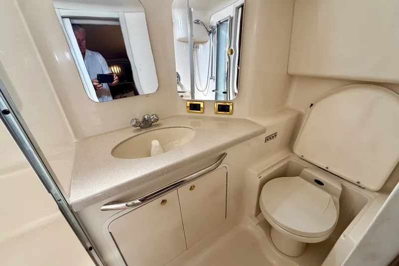 Slide: The Image of 2000 Sea Ray 380 Aft Cabin bathroom with sink, mirror, and toilet. - 11