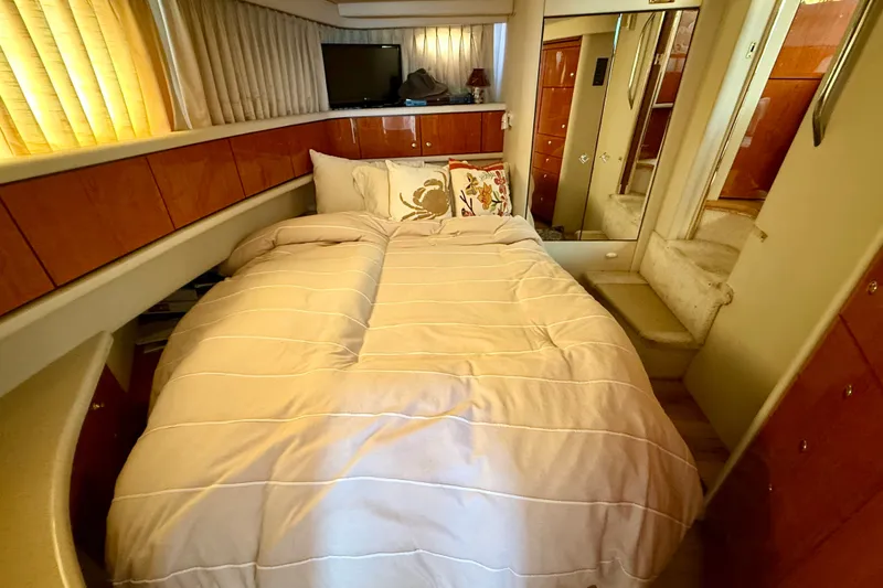 Slide: The Image of Cozy bedroom in 2000 Sea Ray 380 Aft Cabin yacht with elegant wood paneling. - 10