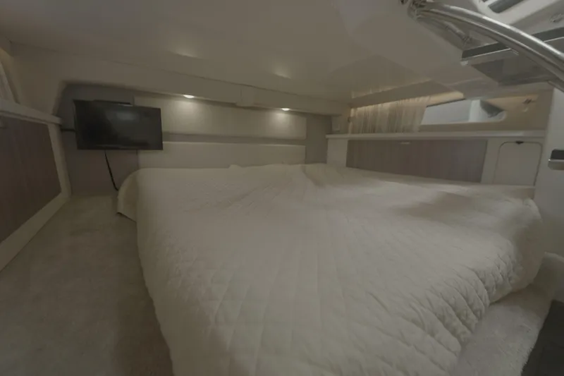 Slide: The Image of Luxurious interior cabin of 2021 Regal 33 XO yacht with cozy bedding and TV. - 21