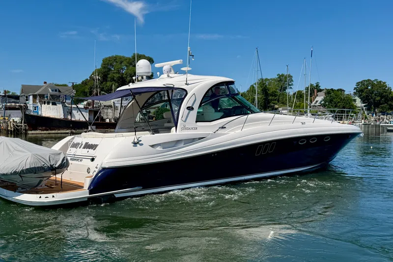 Slide: The Image of 2006 Sea Ray 52 Sundancer yacht cruising in a marina under clear blue skies. - 24