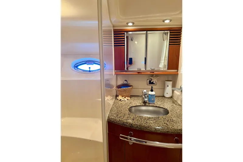 Slide: The Image of Luxurious bathroom in 2006 Sea Ray 52 Sundancer yacht with granite countertop and porthole window. - 39