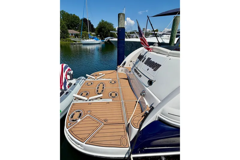 Slide: The Image of 2006 Sea Ray 52 Sundancer yacht docked, featuring a spacious teak swim platform. - 27