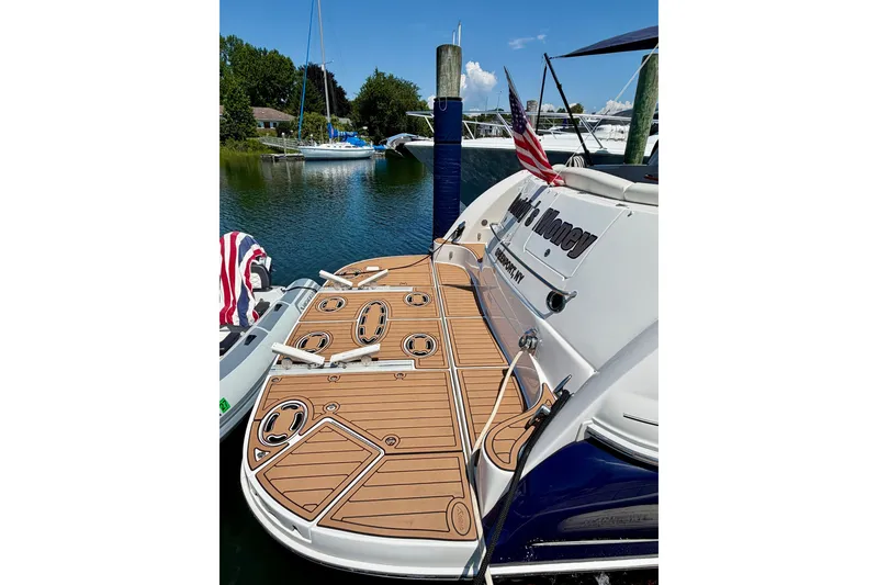 Slide: The Image of 2006 Sea Ray 52 Sundancer yacht docked, featuring a spacious teak swim platform. - 28