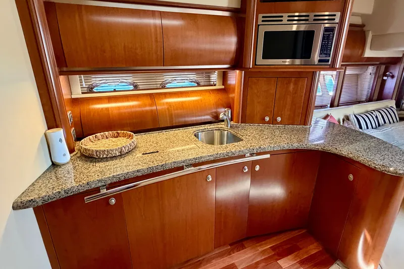 Slide: The Image of Luxurious 2006 Sea Ray 52 Sundancer yacht kitchen with granite countertops and wood cabinetry. - 41
