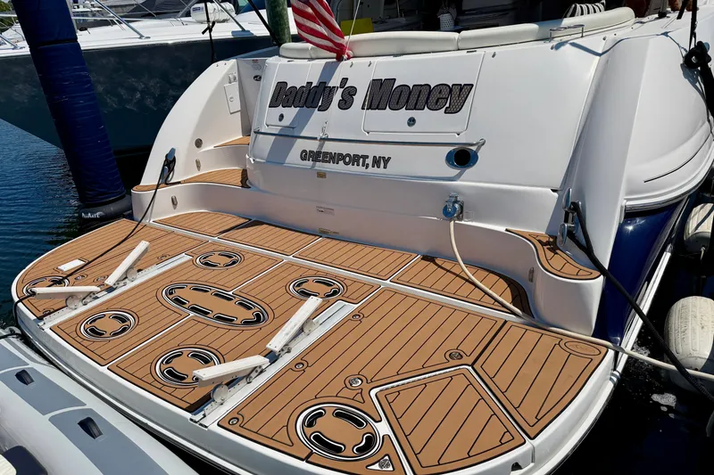 Slide: The Image of 2006 Sea Ray 52 Sundancer yacht docked, featuring custom deck and "Daddy's Money" nameplate. - 26