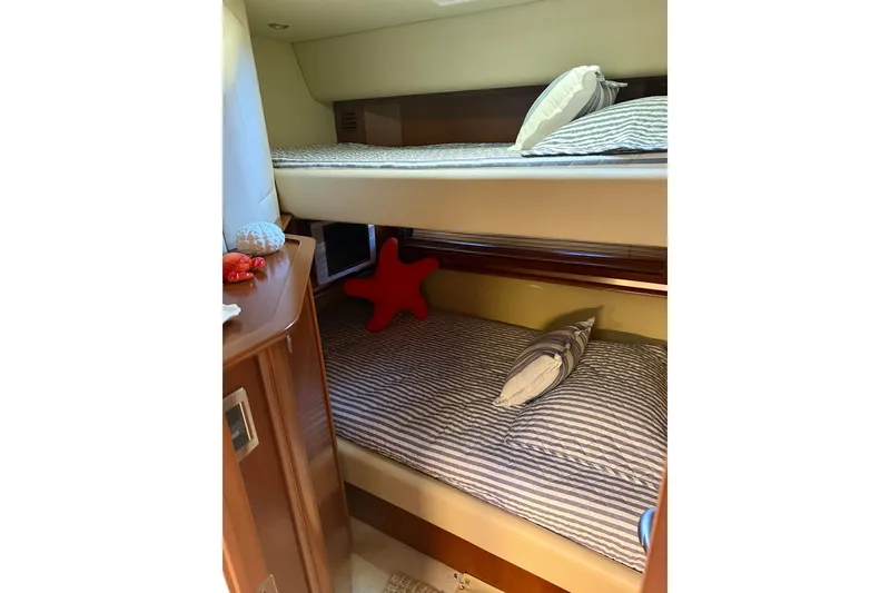 Slide: The Image of Bunk beds in 2006 Sea Ray 52 Sundancer yacht cabin with striped bedding and red starfish pillow. - 37