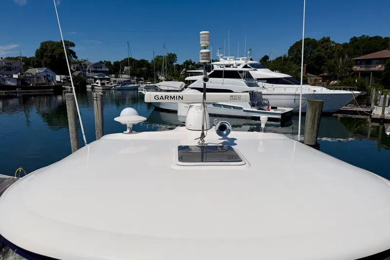 Slide: The Image of 2006 Sea Ray 52 Sundancer yacht docked in a marina, clear blue sky. - 31