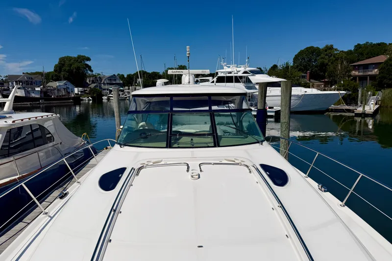 Slide: The Image of 2006 Sea Ray 52 Sundancer yacht docked in a serene marina under a clear blue sky. - 30