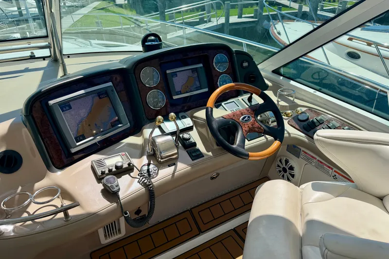 Slide: The Image of Cockpit of 2006 Sea Ray 52 Sundancer with navigation screens and steering wheel. - 46