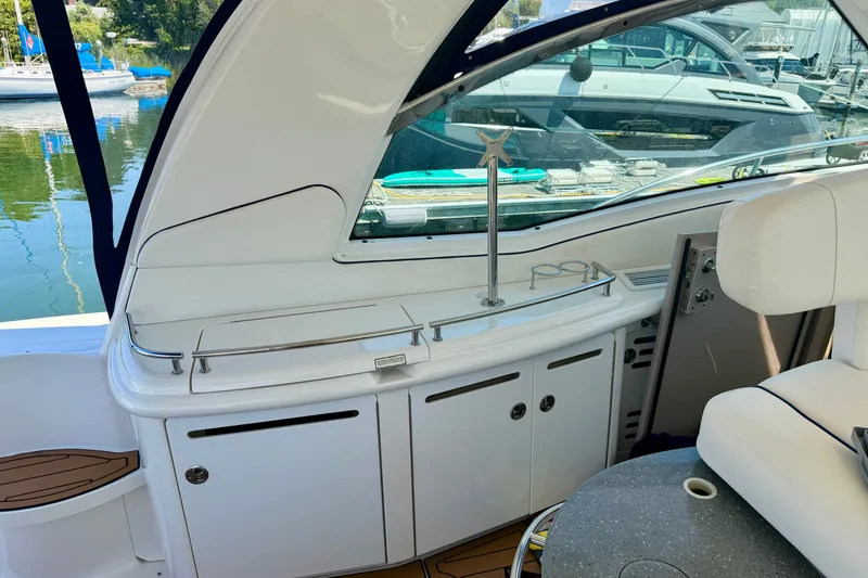 Slide: The Image of Interior view of a 2006 Sea Ray 52 Sundancer yacht, featuring sleek white cabinetry and seating. - 53