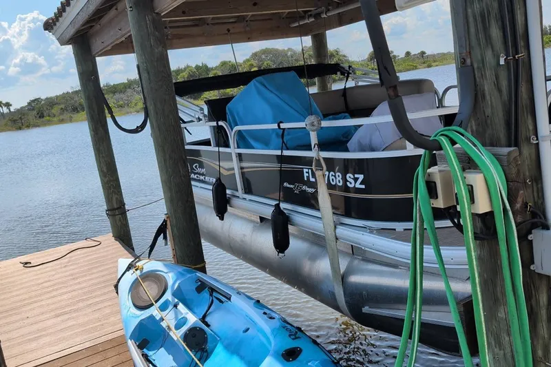 Slide: The Image of 2021 Sun Tracker Bass Buggy 16 XL pontoon boat docked beside a blue kayak. - 18