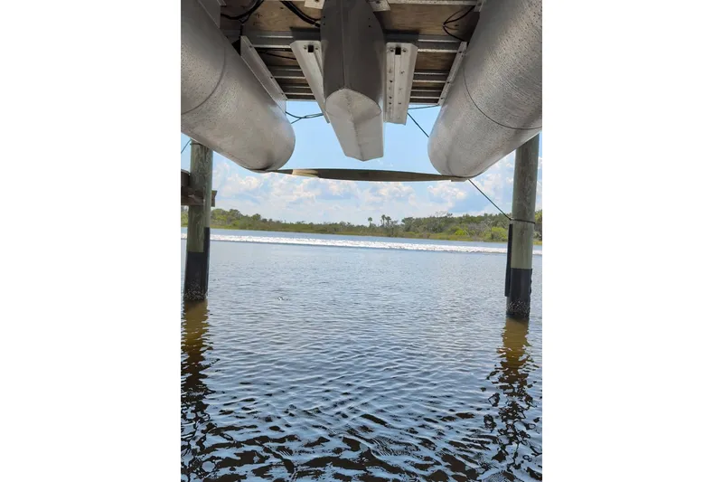 Slide: The Image of Underneath view of a 2021 Sun Tracker Bass Buggy 16 XL pontoon boat on water. - 13