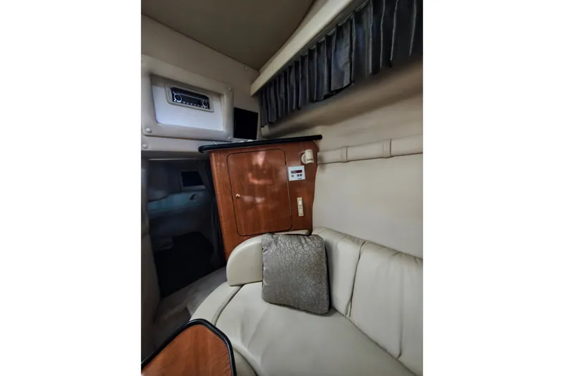 Slide: The Image of Interior of 2002 Regal Commodore 2860 boat with beige seating and wooden cabinetry. - 27