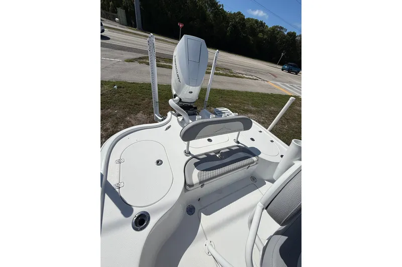 Slide: The Image of 2025 Turner Boatworks 2500 VS deck with seating and motor, parked near a road. - 13