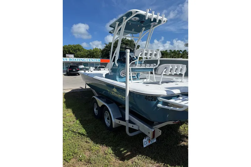Slide: The Image of 2025 Turner Boatworks 2500 VS on trailer at boating center, under clear blue sky. - 5