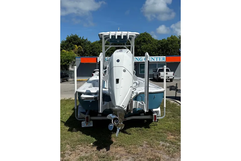 Slide: The Image of 2025 Turner Boatworks 2500 VS, rear view, parked on grass under a clear sky. - 6