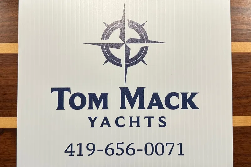 Slide: The Image of Tom Mack Yachts sign with compass logo and contact number, promoting Grady-White 281 Coastal Explorer 2023. - 23
