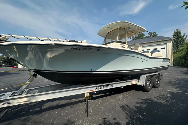 Slide: The Image of 2023 Grady-White 281 Coastal Explorer boat on trailer, parked outdoors. - 2