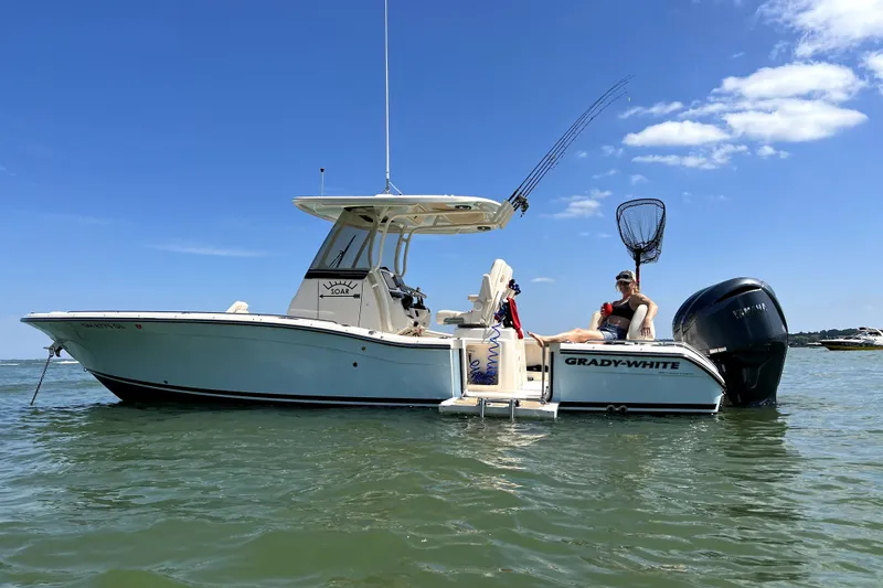 Slide: The Image of 2023 Grady-White 281 Coastal Explorer boat on water, sunny day, person relaxing onboard. - 6