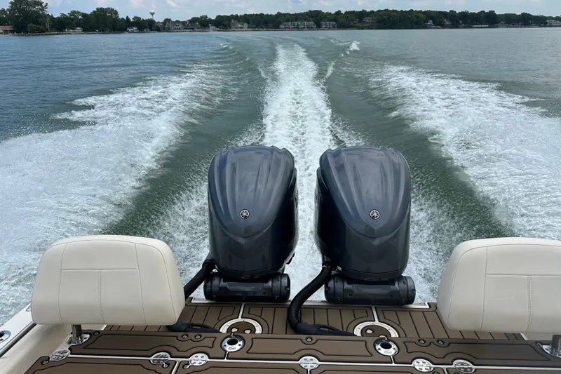 Slide: The Image of 2023 Grady-White 281 Coastal Explorer boat with dual engines cruising on a lake. - 19