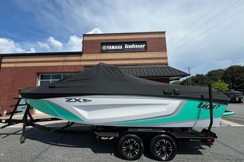 Slide: The Image of 2020 Tigé 23ZX boat with cover, parked outside Yamaha Indmar building. - 13
