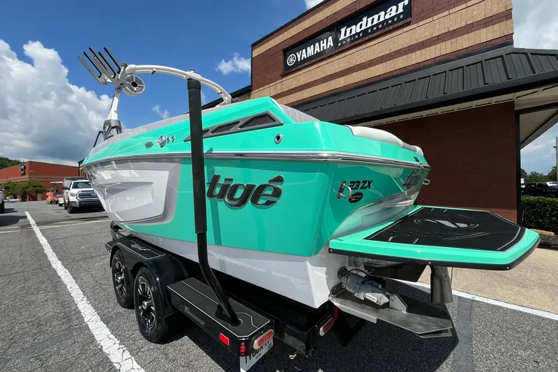 Slide: The Image of 2020 Tigé 23ZX boat in vibrant teal, parked outside Yamaha Indmar dealership. - 5