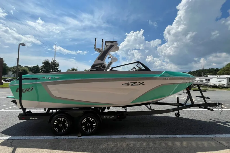 The Image of 2020 Tigé 23ZX boat on trailer under a partly cloudy sky. - 0